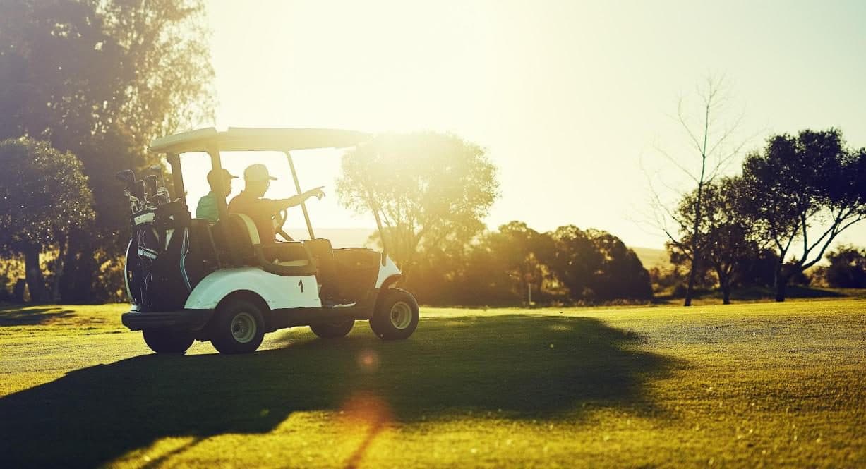 Golf buggy on the fairway at sunset