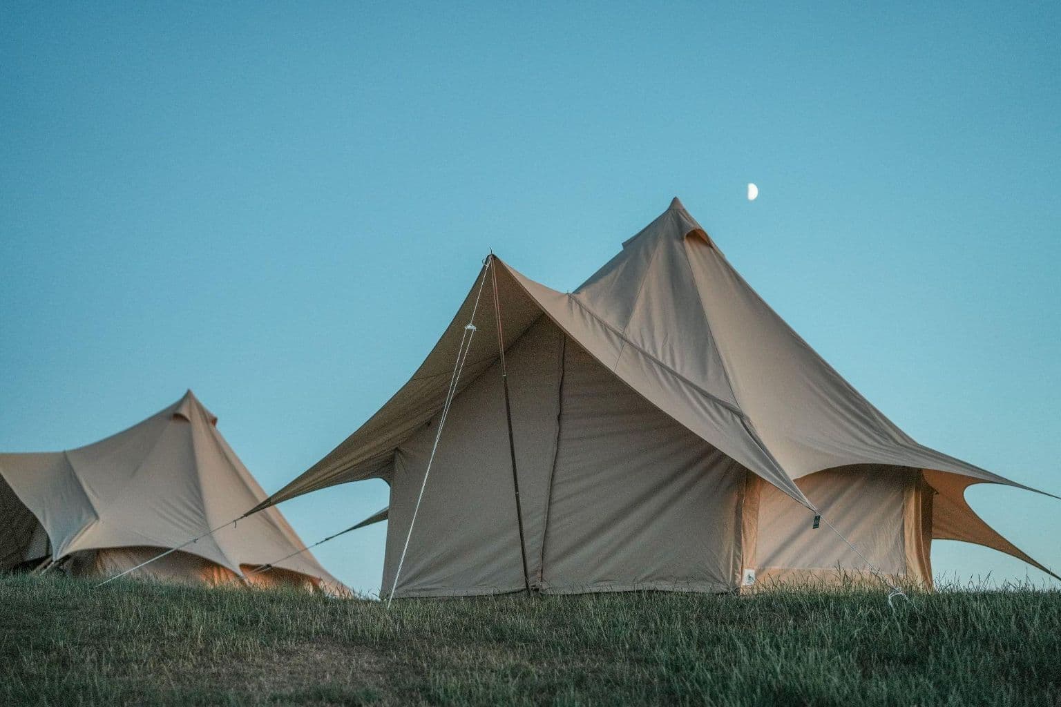 Bell tents under a blue sky inside the circuit