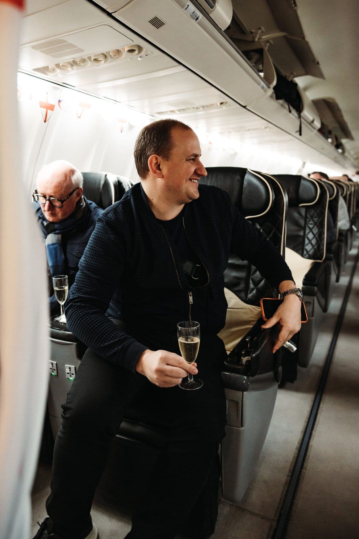 A guest with champagne in the aisle of the private charter